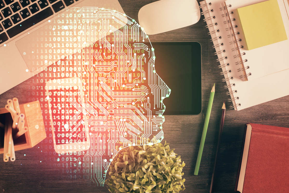 Ein Hologramm-Kopf, der für KI steht ist über einem Arbeitsplatz eingeblendet.